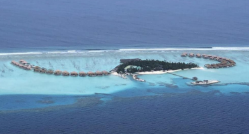 Aerial view of a resort island under construction with beaches and a lagoon.
