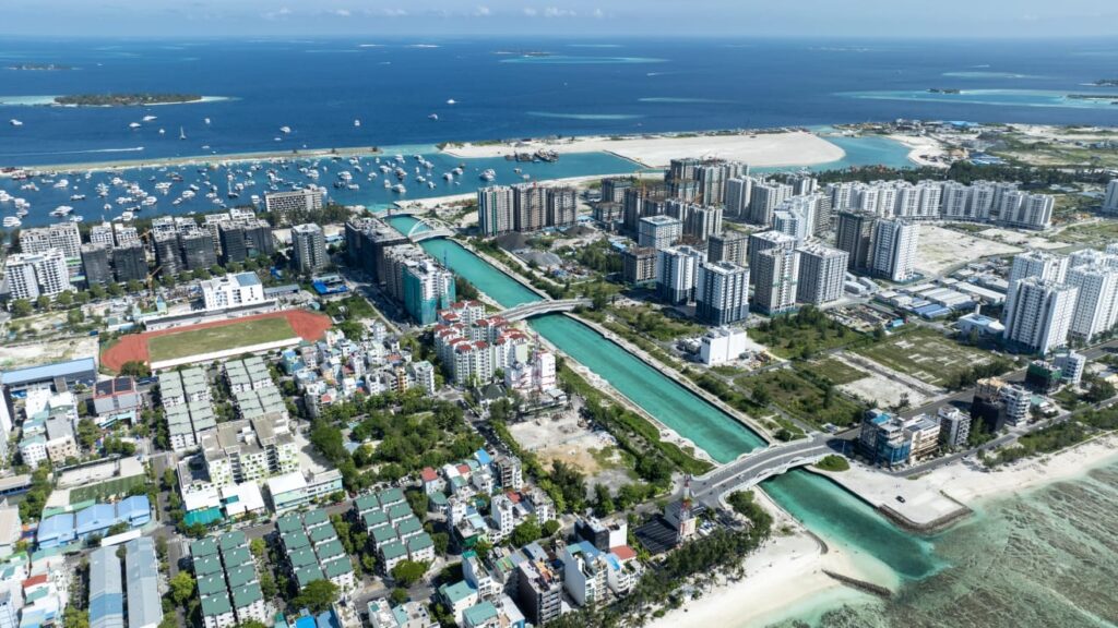 Aerial view of Malé with the harbor, apartment blocks, and the lagoon beyond.